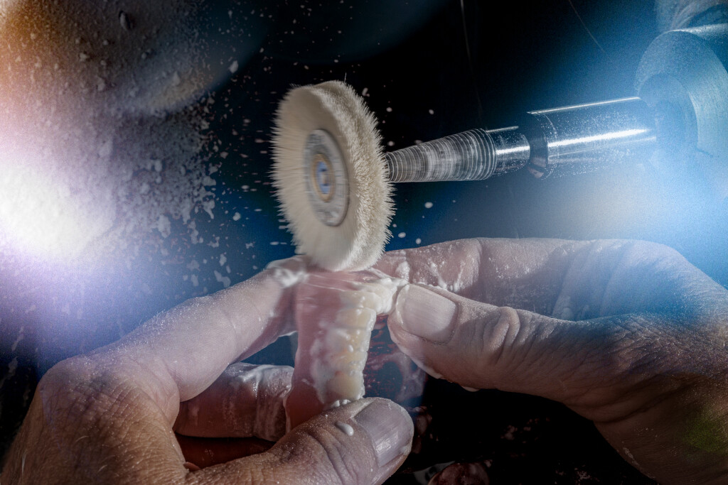 es wird eine Prothese mit Bimssteinpulver auf Hochglanz gebracht